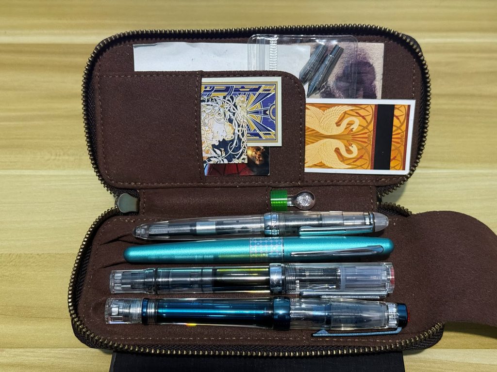 A zippered pen case holding a small collection of fountain pens from the local fountain pen community